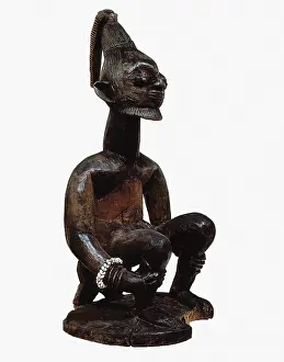Nigerians: Figure on a log. Yoruba art