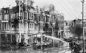 Smoldering: Fire engine spraying water on burned buildings in