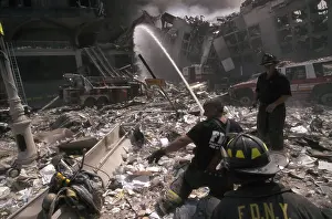 Nyfd: Fire fighters set up a hose amid smoking rubble