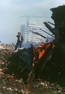 Wasteland: Fire on waste ground with new building in background