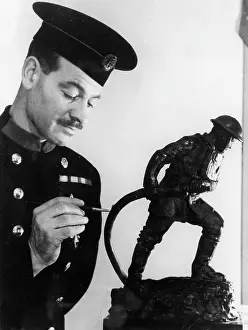 Paintbrush: Firefighter painting statuette of fireman in action