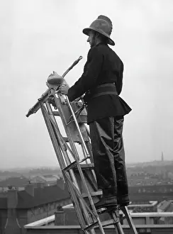 Waterproofs: Firefighter using hook belt at top of ladder