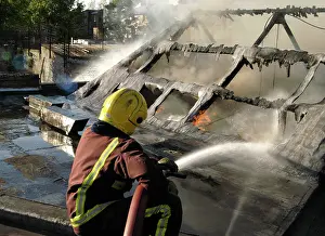 Hosing: Firefighter working at scene of fire, New Cross