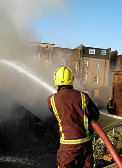 Hosing: Firefighter working at scene of fire at New Cross