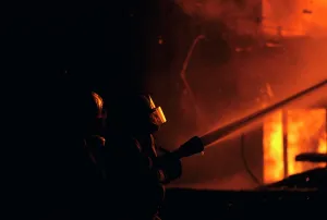 Forceful: Two Firefighters Wearing Face Shields Using Fire Hose to