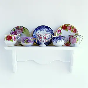 Teacups: FLORAL PATTERNED TEACUPS AND SAUCERS ON MANTELPIECE