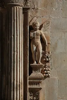 Jordi: Fluted column flanked by a cherub holding a book