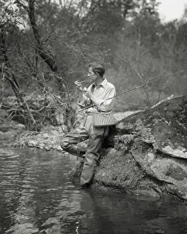 Rewarding: Fly Fisherman Wearing Waders Lighting Pipe Taking