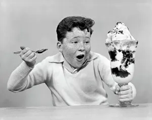 Sundae: Freckle face boy digging into giant ice cream