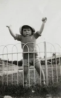 Railings: Funny little toddler boy pretending to be a Strongman
