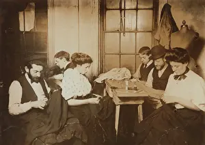 Sweatshop: Garment workers sewing by hand in a small ?