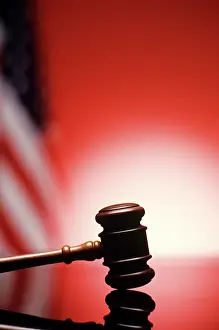 Highlighted: Gavel Resting on Reflective Bench Surface with American F
