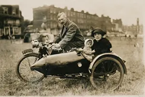Bikers: Gentleman, lady & baby pose on unknown motorcycle