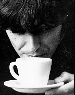 Sitarist: George Harrison of The Beatles pop group, cup of tea