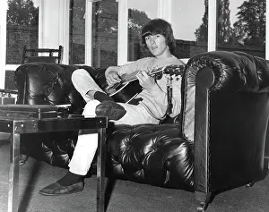 Weybridge: George Harrison of The Beatles relaxes with guitar