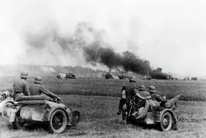 German Soviet: German motorcycle troops pass by burning Soviet vehicles