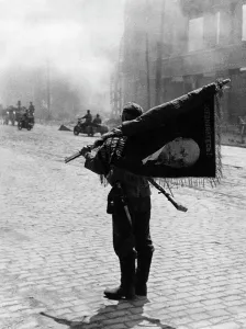 Advancing: German soldier with a captured Soviet flag in Brest-Litowsk