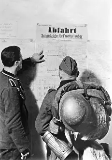 Timetable: German soldiers study a train timetable