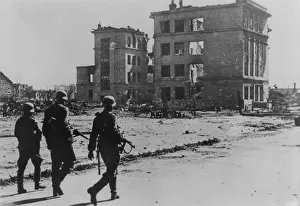 Aerial Bombing: Three German soldiers walking in desolate street