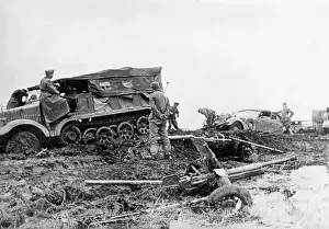 Stranded: German tractor pulls a car which stranded in the mud, 1941
