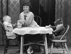 Wholesome: Girl having tea party with doll and bear