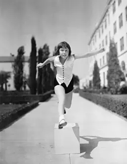 Goodtime: Girl leaping over wooden blocks