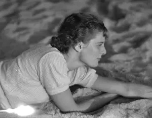 Tummy: Girl lies on the sand
