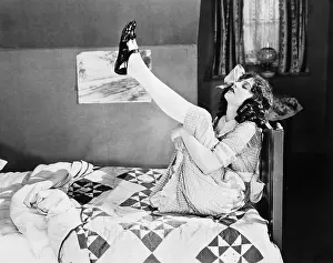 Quilt: Girl sitting on a bed, pulling her legs up