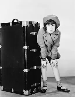 Concealment: Girl standing next to suitcase