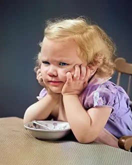 Irate: Girl at Table with Head Cradled in Both Hands