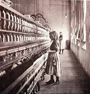 Tending: Girl tending a spinning machine, circa 1900. At