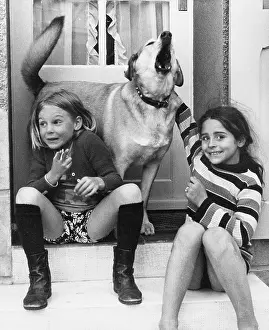 Two girls and a dog on a doorstep
