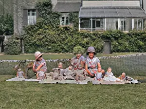 Three girls in a garden with dolls