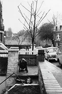 Suspiciously: Girl's head emerging from a coal hole