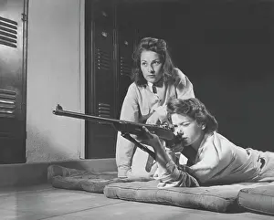 Accuracy: Girls practice marksmanship in high school hall. circa 1942