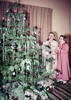 Two Girls Standing in Front of Christmas Tree