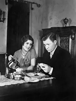 Tenderness: Glum man and adoring woman at breakfast table