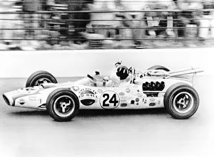 Streaks: Graham Hill, waves as his car streaks toward the