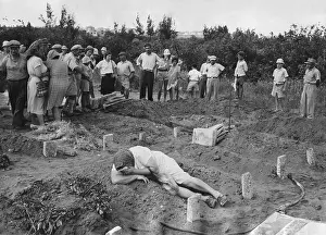 Accounting: A grief stricken mother lying on the grave of