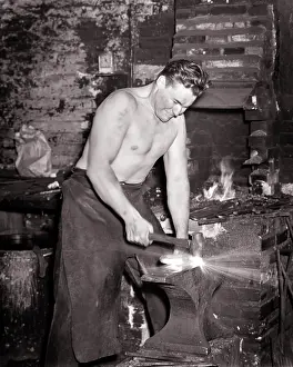 Grimacing: Grinning Hard Working Barechested Man Blacksmith Craftsman