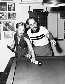 50 59: Groucho Marx at home playing billiards with his