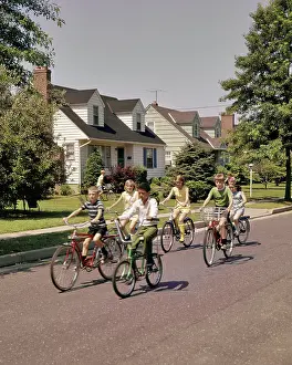 Preteen: Group Children Riding Bikes Down Suburban