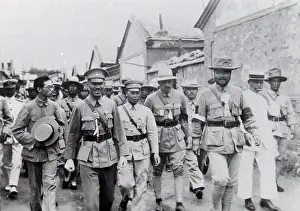 Dignitaries: Group of dignitaries walking along a street, Far East