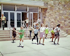 Ethnically: Group of Ethnically Diverse Kids Running Out of School Build