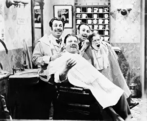 Cooperate: Group of four men at a barber shop singing