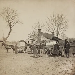 Darkroom: A group of men stand next to wagons labeled