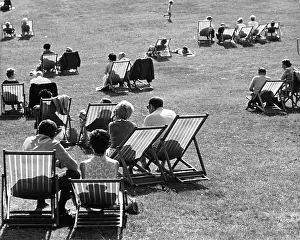 Kenwood: Group of people on deckchairs in a park with shadows