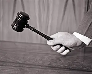 Pounding: Hand Holding a Gavel Poised to Strike