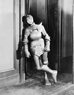 Exhausting: A hard night for knight in a armor leaning against a wall