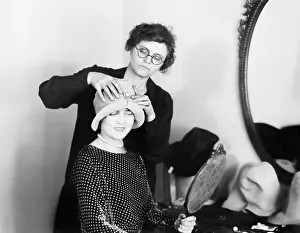 Esteem: A hat maker fitting a hat on a customer